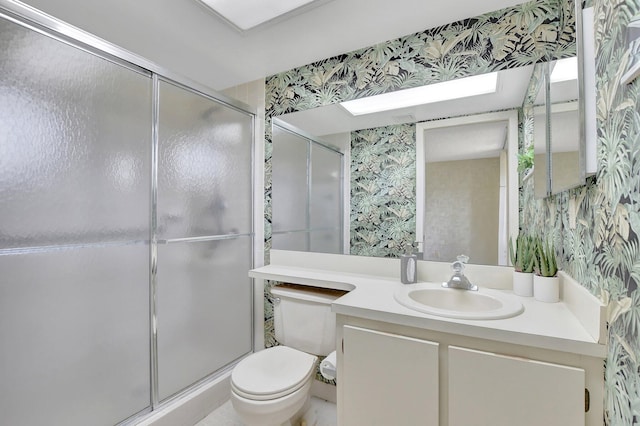 bathroom with vanity, toilet, and a shower with shower door