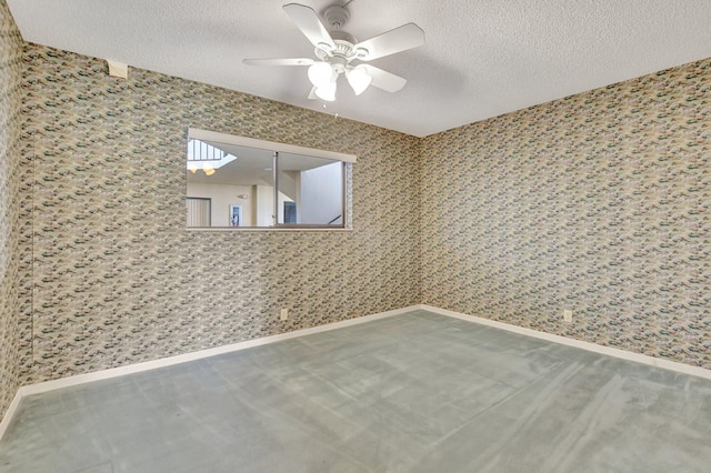 unfurnished room with ceiling fan and a textured ceiling