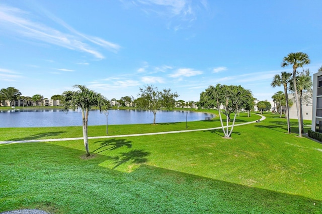 view of property's community with a water view and a lawn