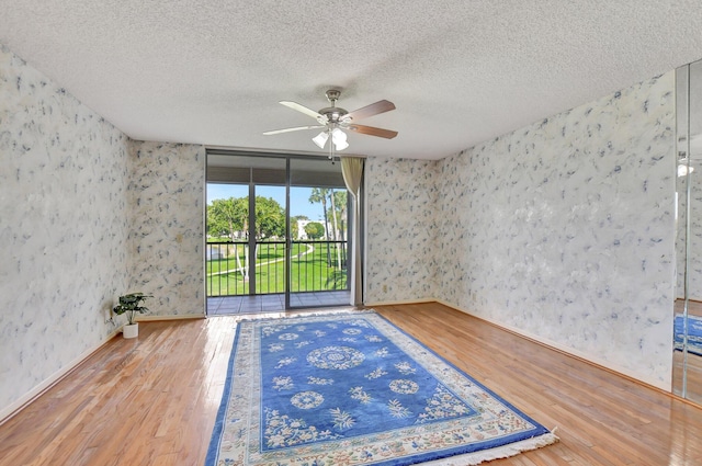 spare room with ceiling fan, hardwood / wood-style flooring, and a textured ceiling