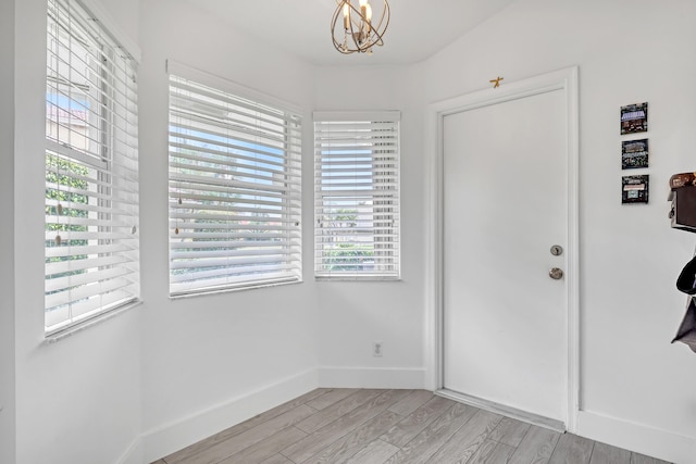 foyer featuring an inviting chandelier and light hardwood / wood-style flooring