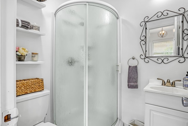 bathroom featuring vanity, toilet, and a shower with shower door