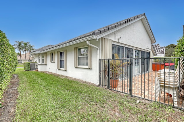 view of property exterior featuring a yard and central air condition unit