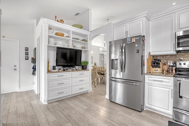 kitchen featuring white cabinetry, appliances with stainless steel finishes, light hardwood / wood-style floors, and stone counters