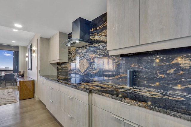 kitchen featuring tasteful backsplash, dark stone countertops, black electric stovetop, light wood-type flooring, and wall chimney exhaust hood