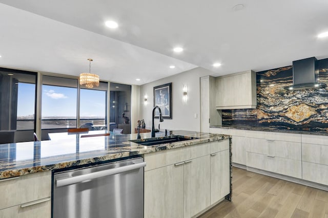 kitchen featuring sink, wall chimney range hood, dishwasher, stone counters, and light hardwood / wood-style floors