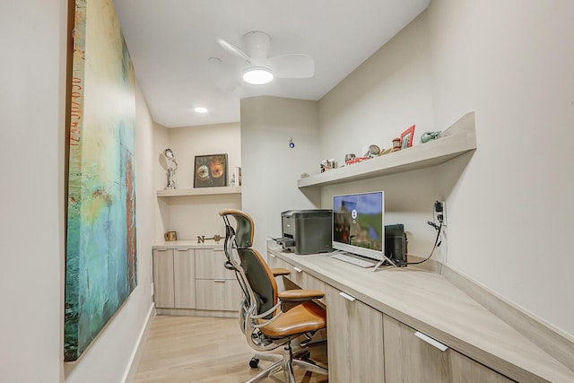 office space with light hardwood / wood-style flooring, built in desk, and ceiling fan