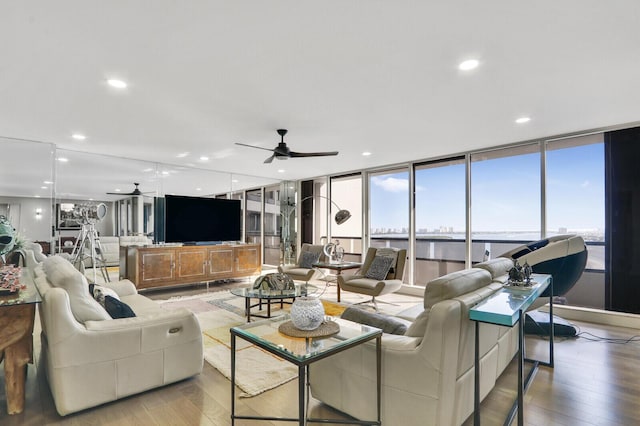 living room featuring wood-type flooring and ceiling fan