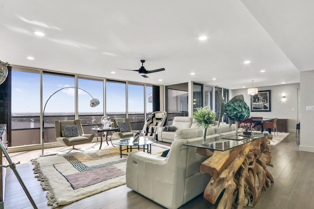 living room featuring expansive windows, ceiling fan, and light hardwood / wood-style flooring