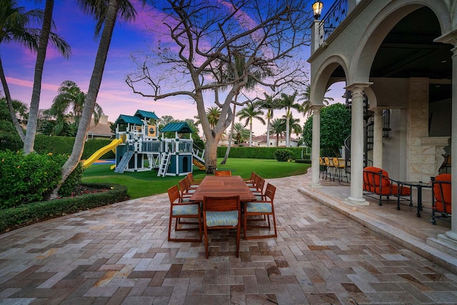 patio terrace at dusk with a playground and a lawn