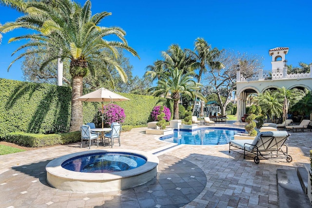 view of pool with an in ground hot tub and a patio