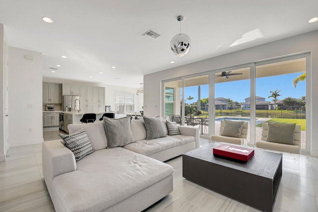 living room featuring recessed lighting, visible vents, light tile patterned flooring, and an inviting chandelier