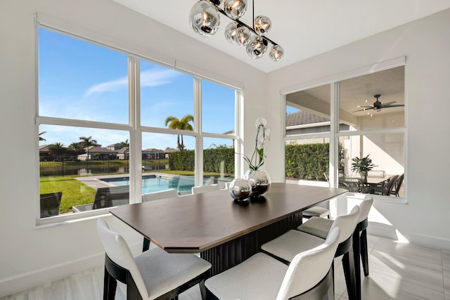 dining area featuring ceiling fan with notable chandelier