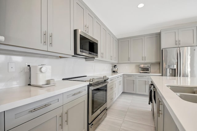 kitchen featuring appliances with stainless steel finishes and gray cabinetry