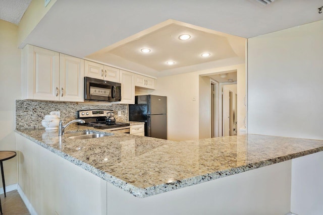 kitchen featuring sink, black appliances, kitchen peninsula, light stone countertops, and tasteful backsplash