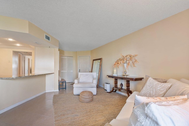 interior space featuring a textured ceiling and light tile patterned floors