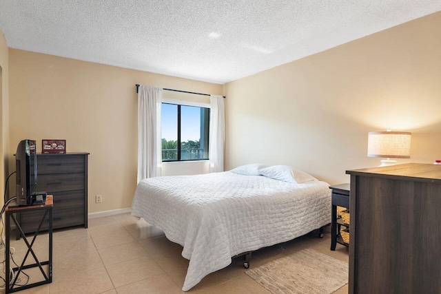 bedroom featuring light tile patterned flooring and a textured ceiling