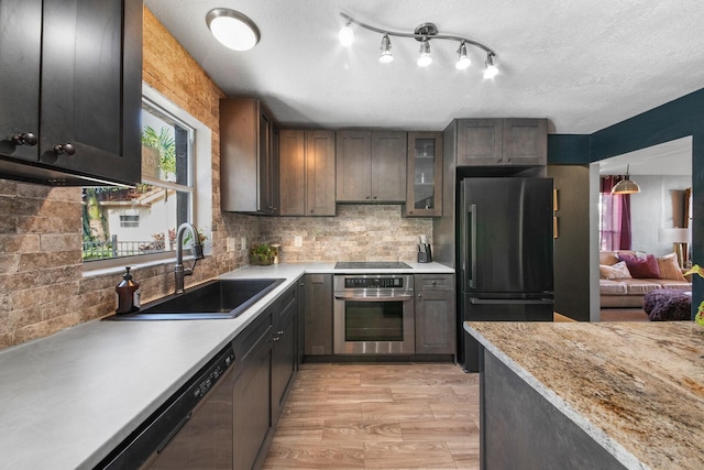 kitchen featuring sink, tasteful backsplash, refrigerator, dark brown cabinets, and oven