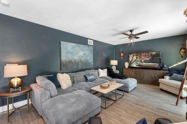 living room with light hardwood / wood-style flooring and ceiling fan