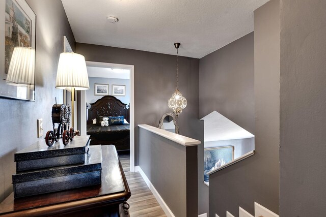 bedroom with multiple windows, wood-type flooring, lofted ceiling, and a chandelier