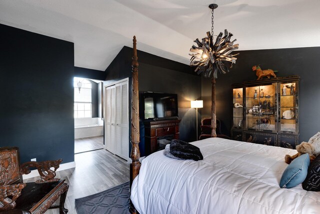 bathroom with hardwood / wood-style flooring, plus walk in shower, and vaulted ceiling