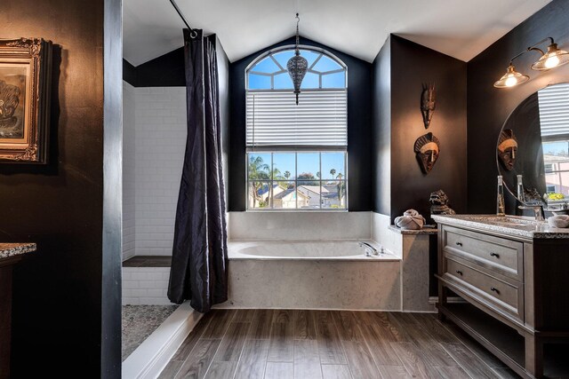 bathroom with hardwood / wood-style flooring, a tub to relax in, and vanity