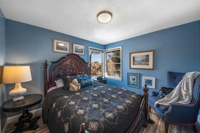 bedroom featuring hardwood / wood-style flooring and a textured ceiling