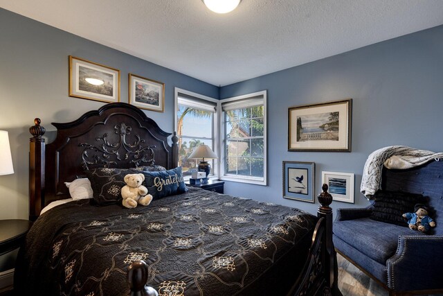 bedroom featuring wood-type flooring and a textured ceiling