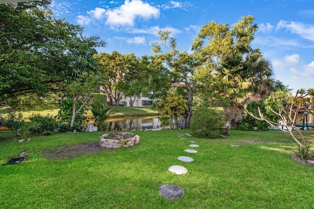 view of yard with a water view and an outdoor fire pit