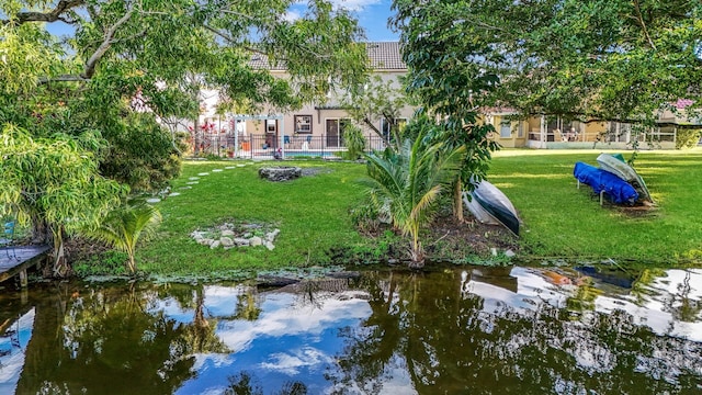 view of home's community featuring a water view and a lawn