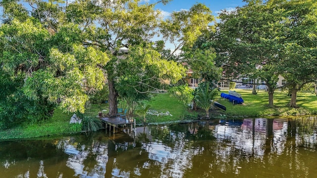 view of dock featuring a water view and a lawn