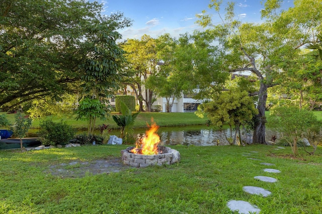 view of yard with a water view and an outdoor fire pit