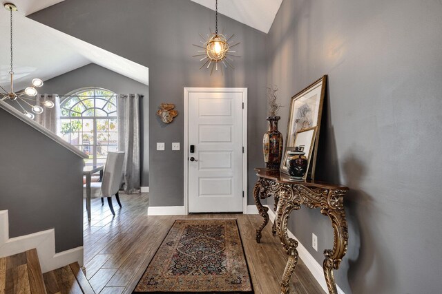 dining area with hardwood / wood-style flooring, lofted ceiling, and a chandelier