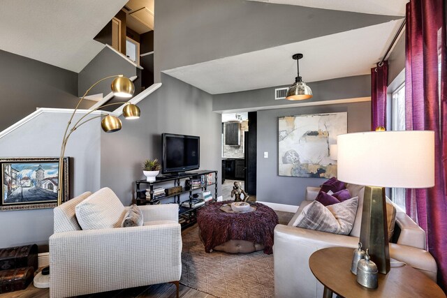 living room featuring dark hardwood / wood-style floors, vaulted ceiling, a healthy amount of sunlight, and an inviting chandelier