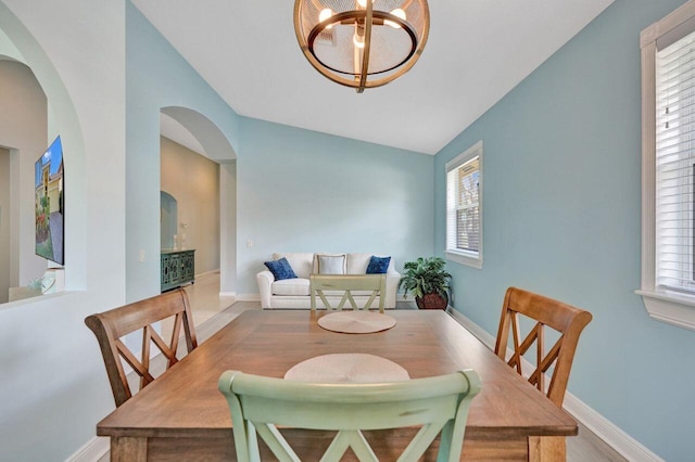 dining space featuring lofted ceiling and a notable chandelier