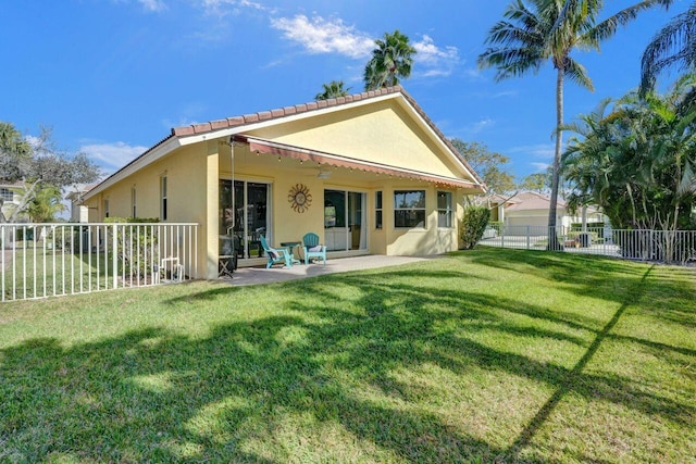 rear view of property featuring a patio area and a lawn