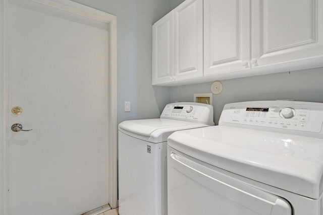 washroom featuring cabinets and independent washer and dryer