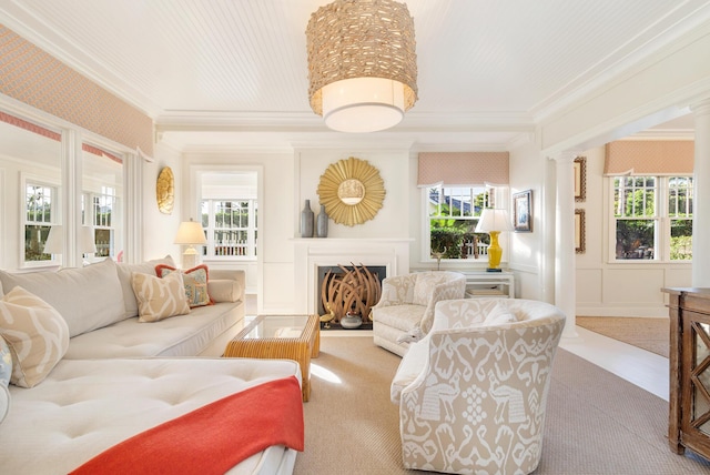 living room with ornate columns, ornamental molding, and plenty of natural light