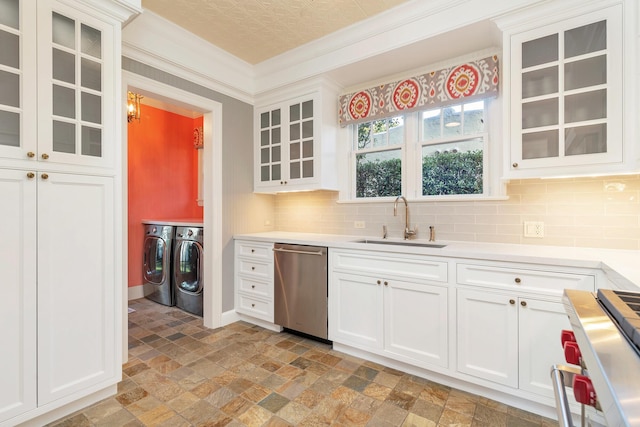 kitchen with washer and dryer, tasteful backsplash, white cabinetry, sink, and stainless steel appliances