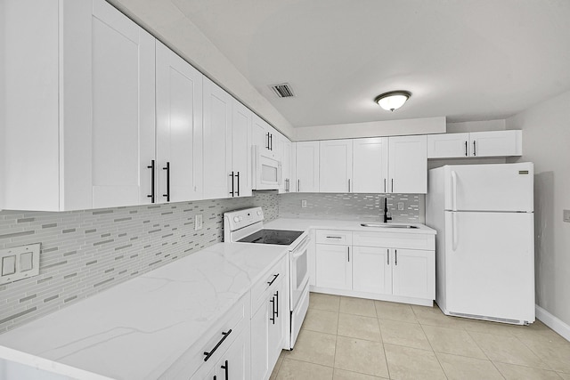 kitchen featuring light tile patterned flooring, sink, white appliances, decorative backsplash, and white cabinets