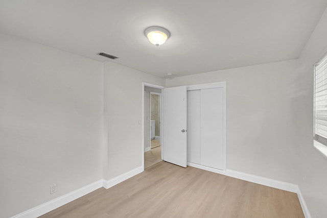 unfurnished bedroom featuring light hardwood / wood-style floors and a closet