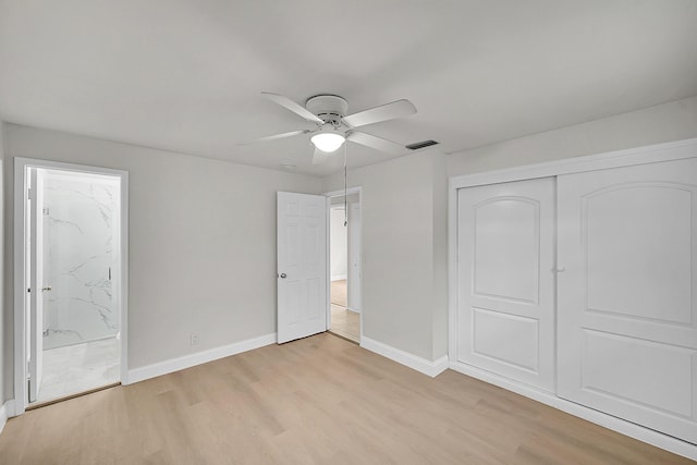 unfurnished bedroom featuring light hardwood / wood-style flooring, a closet, ceiling fan, and ensuite bathroom