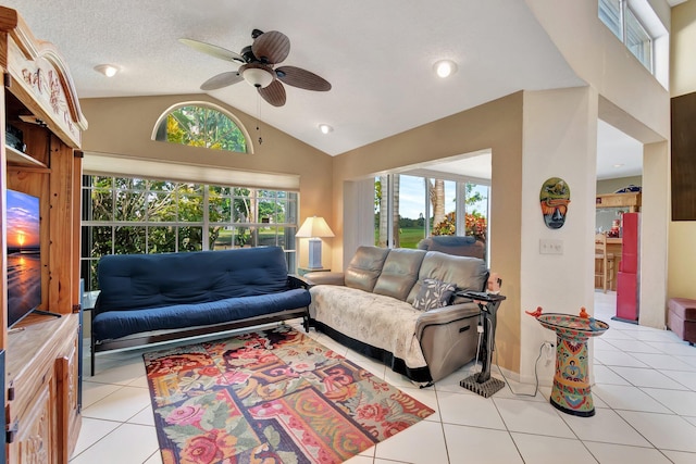 living room with lofted ceiling, light tile patterned floors, a wealth of natural light, and ceiling fan