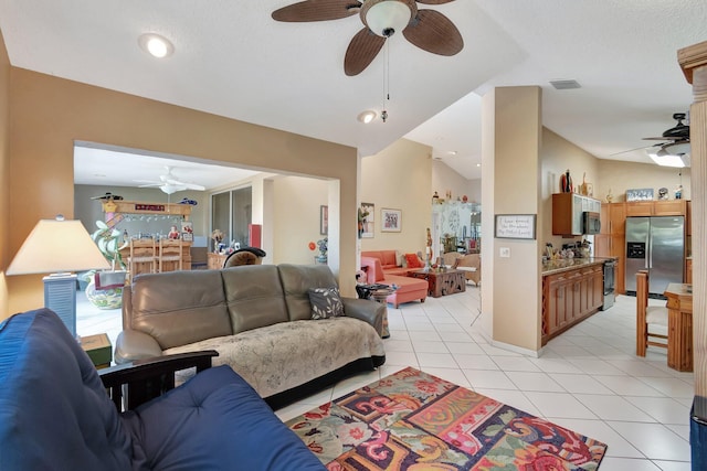 living room with ceiling fan, lofted ceiling, and light tile patterned floors