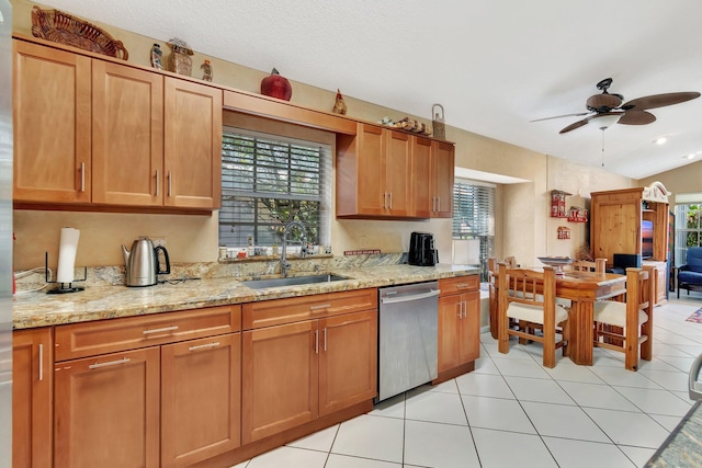 kitchen featuring dishwasher, sink, light stone countertops, and a wealth of natural light