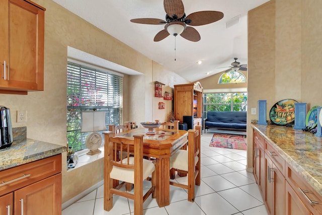 tiled dining space with lofted ceiling and ceiling fan