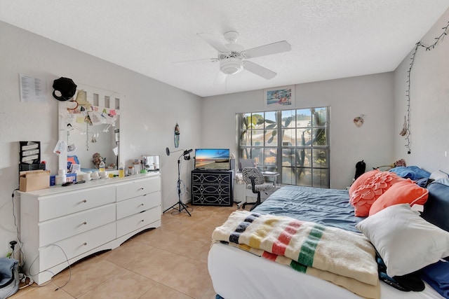 bedroom with a textured ceiling, ceiling fan, and light tile patterned flooring