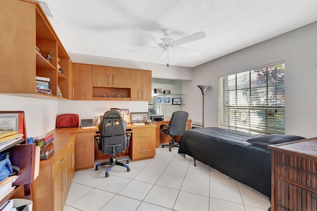 bedroom with built in desk, a textured ceiling, and light tile patterned floors