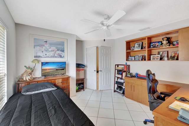 tiled home office featuring ceiling fan and a textured ceiling