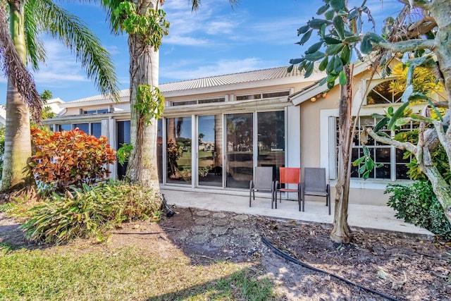 back of property with a patio and a sunroom